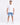 A man stands confidently in a fitted white t-shirt paired with light blue denim shorts and white sneakers.