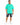 A man stands wearing a bright green oversized t-shirt with a graphic text design, paired with distressed black shorts...