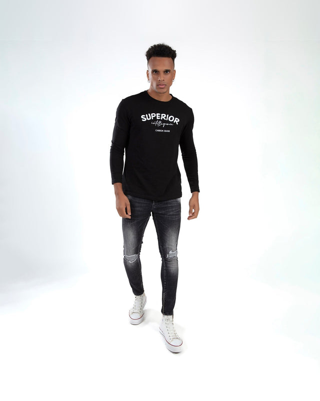 Model in black Carbon Superior Intelligence long-sleeve shirt, distressed skinny jeans, and white sneakers.
