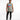 A man wearing a sleeveless light gray top with colorful text, paired with black jeans and white sneakers.