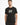 A man wearing a black t-shirt featuring a colorful geometric design on the front, standing against a white background.