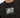 A close-up of a black t-shirt featuring a colorful geometric pattern and a handwritten-style text design.