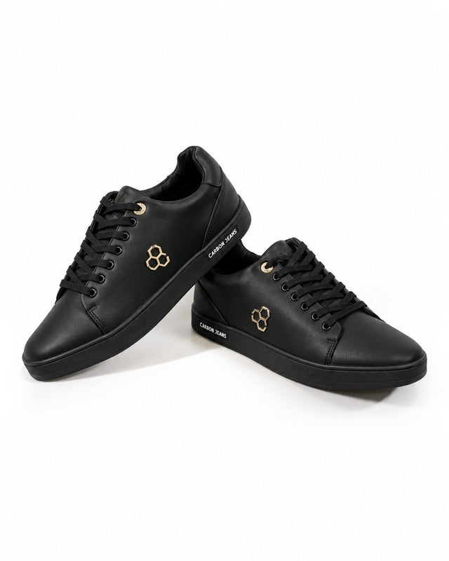 Black lace-up sneakers featuring a gold emblem and a textured sole for casual wear.