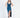 A model poses in a deep blue satin dress with a plunging neckline and a thigh-high slit, paired with black heels.