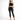 A model poses in a black lace crop top and fitted black jeans, paired with strappy black heels.