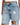 Light blue distressed denim jeans featuring ripped details and a high-waisted fit, styled with a white top.