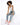 A model poses on a white block, wearing a fitted tank top, distressed jeans, and colorful sneakers.