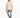 A man stands wearing a textured beige shirt jacket over a white t-shirt, paired with distressed gray jeans and white...