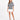 A model poses in a gray tie-dye tee featuring playful graphics, paired with a white mini skirt and black heels.