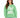 A woman wearing a green sweatshirt with bold white lettering and a casual style, paired with light jeans.