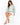 A woman sits on a stool wearing a mint green sweatshirt with a graphic design, paired with white shorts and beige heels.