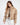 Model wearing the Thea beige puffer coat with a high collar and ring-pull zipper in a cropped fit.