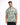 A man models a short-sleeve, patterned shirt featuring green and beige geometric designs.