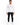 A man stands confidently in a fitted long-sleeve white shirt featuring a circular graphic and text, paired with black...