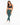 A model poses in fitted green leggings paired with a dark sports bra and white sneakers against a plain background.