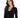 A woman with long, wavy hair wears a black long-sleeve top featuring a decorative chain and button neckline.