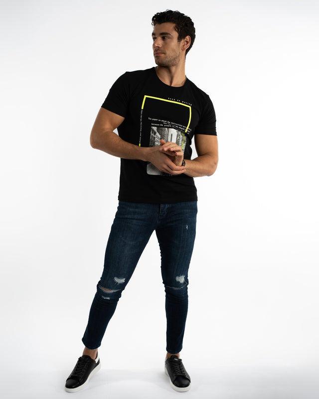 Model wearing Carbon Marco Dark Blue Denim with distressed knee details and a black graphic t-shirt.
