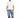 A man stands wearing a loose-fitting white t-shirt and light blue patchwork jeans, paired with white sneakers.