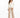 A woman stands confidently in a fitted cream jacket paired with beige wide-leg trousers and black heels.