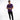 A man stands confidently in a purple short-sleeve shirt and black jeans, wearing white sneakers.