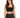 A woman with long, wavy hair wears a fitted black crop top and high-waisted black denim shorts.
