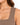 Close-up of a model's shoulder and neckline showcasing a ribbed, sleeveless top in a warm brown hue.
