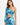 A model poses in a colorful, abstract-patterned crop top with one long sleeve and a matching skirt.