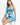 A model poses in a vibrant blue and turquoise one-shoulder top paired with a matching ruched skirt.