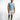 A man stands confidently in a light blue short-sleeve shirt and distressed white shorts, paired with casual sneakers.