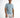 A man stands confidently in a light blue short-sleeve shirt paired with distressed white shorts.