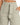 Light gray high-waisted trousers with a tied belt and pleated front, styled with a cropped top.