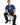 A man sits on a stool wearing a blue t-shirt with a graphic design featuring Las Vegas and playful icons.