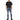 A man stands wearing a black oversized t-shirt, distressed blue jeans, and black sneakers.