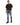 A man stands wearing a black oversized t-shirt, distressed blue jeans, and black sneakers, posing confidently.