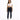 A woman stands confidently in a cropped white top and dark skinny jeans with distressed details, paired with white sn...