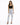 A woman stands confidently in light-wash ripped jeans paired with a black crop top and strappy heels.