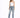A woman poses in distressed light blue jeans with a white one-shoulder top and black high-heeled sandals.
