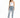 A woman stands confidently in light blue distressed jeans, paired with a fitted white top and black heels.