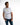 Man in white Mind Power streetwear graphic tee with neon yellow Carbon text and blue denim jeans.