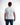 Back view of a man in the white Mind Power streetwear graphic tee and blue jeans against a white background.