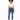 A model poses in a cropped white top with a drawstring and blue skinny jeans, paired with white sneakers.
