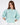 Model wearing a teal knit More and Less cropped sweatshirt with embossed text and puff sleeves against a white background.