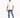 A man wearing a loose white t-shirt and distressed blue jeans, paired with white sneakers, walking confidently.