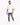 A man wearing a loose white t-shirt and distressed blue jeans, paired with white sneakers, walking confidently.