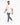 A man walks confidently in distressed blue jeans paired with a light beige oversized t-shirt and white sneakers.