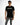 A model wearing a black short-sleeve shirt with a graphic design, paired with distressed gray jeans.