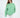 Model wearing the Eve Top, an oversized light green crewneck sweatshirt with 'More and Less' embroidered on the chest.