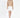 Model wearing Serena cable knit turtleneck sweater in tan with a white mini skirt and heels against a white background.