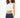 Model wearing the Luna white ribbed cropped tank top with padded shoulders and dark wash denim jeans.