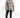 A man wearing a sleeveless light gray top with colorful text, paired with black jeans and white sneakers.